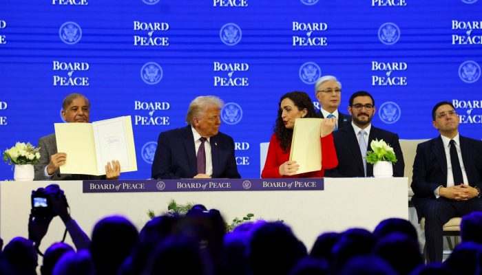 US President Donald Trump with other members of his Board of Peace at the World Economic Forum in...